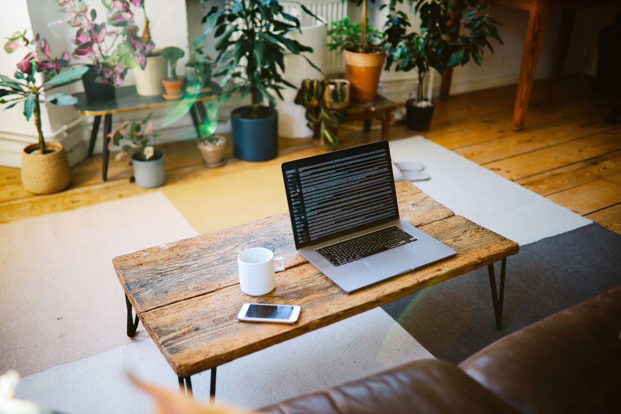 Sunlit farmhouse table with notebook and laptop