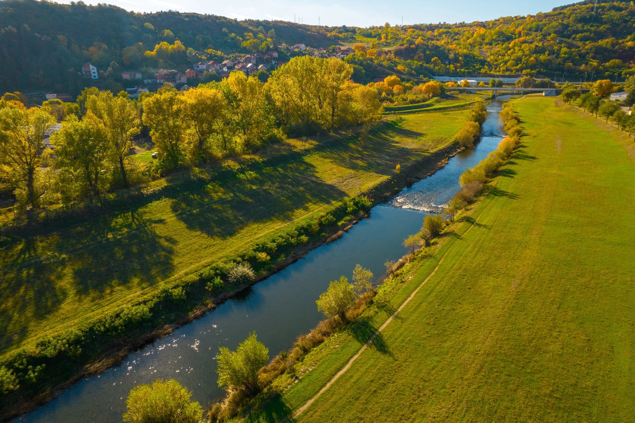 Sunlit river winding through fields and trees